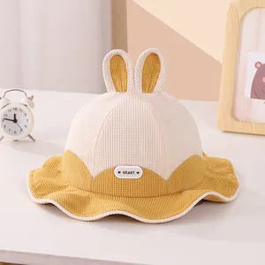 Detail of baby bunny bucket hat featuring plush ears and a HEART rubber patch detail