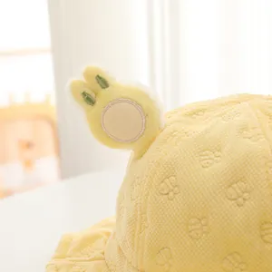 Dettaglio di cappello giallo bebè con orecchie di coniglio e motivo orso waffle