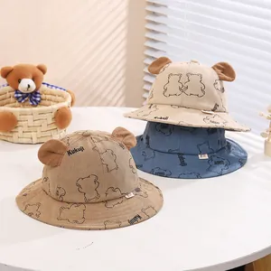 Detailed close-up of corduroy baby bucket hats with plush bear ears and animal prints