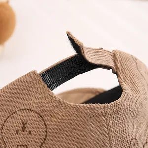 Dettaglio del cinturino in velcro regolabile sul cappello in velluto baby