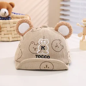Dettaglio del cappellino neonato in velluto beige con orecchie e ricamo di orsetto