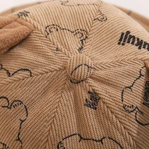 Detailed macro view of brown corduroy bucket hat with cartoon bear and cute plush ears