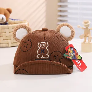 Dettaglio del cappellino neonato in velluto marrone con orecchie da orso e ricamo