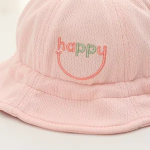 Dettaglio cappello rosa neonato con tessuto a rete traspirante e ricamo happy face