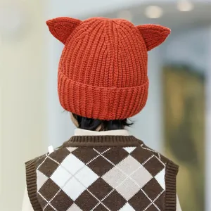 Handmade knitted winter hat for kids featuring cute cat ears in caramel brown wool