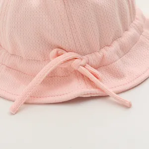 Dettaglio cappello da sole rosa per neonati in tessuto a rete con fiocco sottile