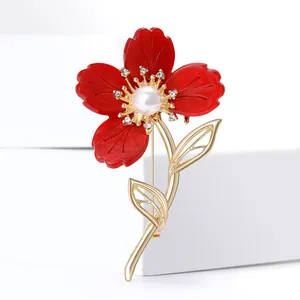 Élégante broche fleur en résine rouge avec feuilles dorées et centre en perles fines