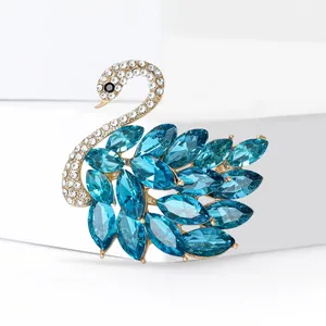 Elegante broche de cisne dorado con cristales azules marquise y brillantes diamantes