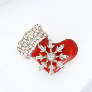Detail of red enamel Christmas stocking brooch with sparkling silver snowflake and rhinestones