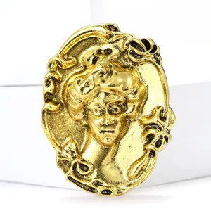 Vintage gold relief brooch featuring a classical woman portrait with black enamel accents