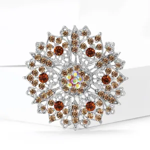 Elegant snowflake brooch with amber crystals and rhinestones on a silver base