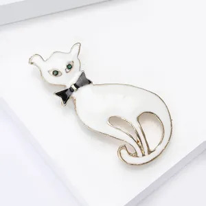 Broche chat élégante en émail blanc avec nœud papillon noir et finition dorée
