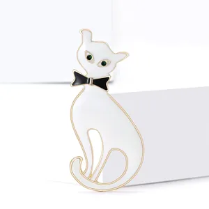 Broche chat gentleman en émail blanc avec yeux en pierres vertes et nœud papillon
