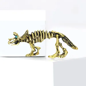 Spilla scheletro di triceratopo in oro retrò con occhio di strass verde su base bianca