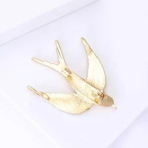 Macro shot of the sturdy safety pin clasp on the back of a gold swallow bird brooch