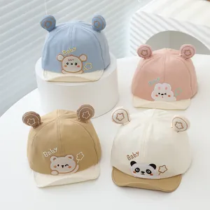 Détail de quatre casquettes de baseball pour bébé avec oreilles d'animaux et broderies