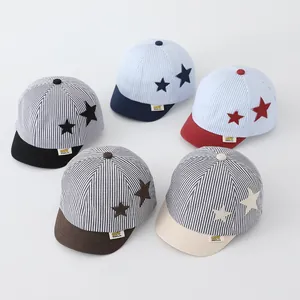 Close-up of baby baseball caps with striped fabric and star patches in five colors