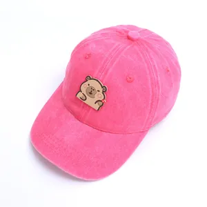 Detalle de gorra de béisbol lavada para niños con parche de carpincho en color rosa rojo