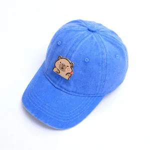 Detalle de la tela de algodón lavado y parche de animal de dibujos en gorra azul de bebé