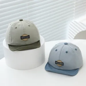 Two soft brim children's baseball caps in olive and blue with college badges