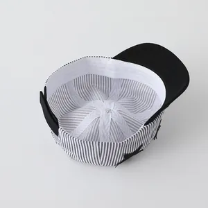 Close-up of baby baseball cap with black and white striped lining and star patch