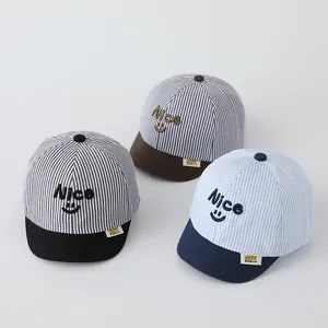 Detailed view of striped baby baseball caps with Nice embroidery and smiley face motifs
