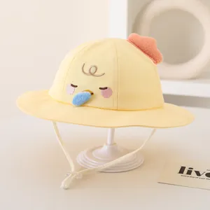 Detail of yellow cotton bucket hat for babies with cute 3D chick embroidery and chin strap