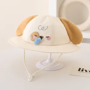 Detail of cream kids sun hat with cartoon dog embroidery and 3D blue pom-pom nose
