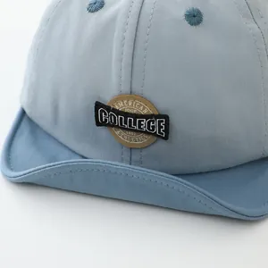 Close-up of cotton baby baseball cap featuring American College embroidery and soft brim