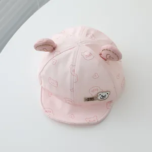 Detail showing the 3D ears and cute bear patch on the pink cotton baby baseball cap
