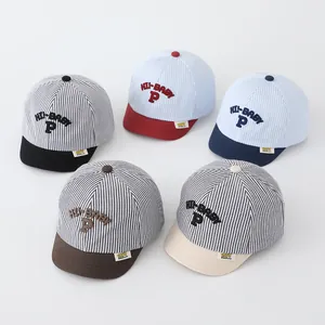 Detailed top view of striped baby baseball caps with soft brims and embroidered letters