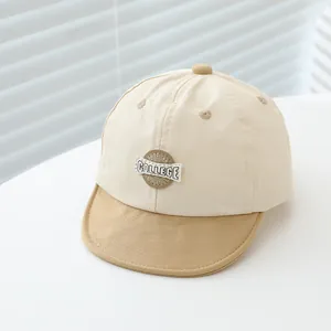 Detail of baby baseball cap featuring cotton twill texture and college badge embroidery