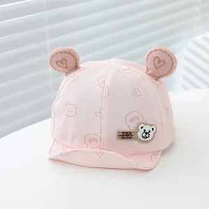 Close-up of pink baby baseball cap with 3D bear ears and gold heart embroidery detail