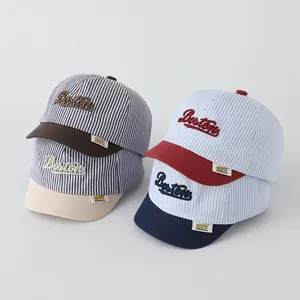 Detail of four colorful striped baby baseball caps featuring Boston embroidery and short brims