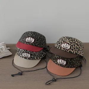 Detail of kids leopard print baseball caps with OKAY embroidery and chin straps