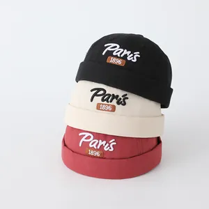 Tre cappelli docker stile cinese in nero, beige e rosso con ricamo Paris 1896