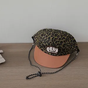 Detail of kids hip hop cap showing leopard print canvas and OKAY embroidery patch