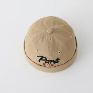 Dettaglio del cappello miki kaki con ricamo Paris e etichetta vintage 1896 in cotone