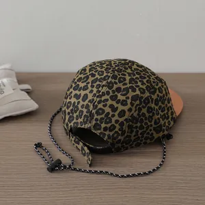 Detail of leopard print camper hat with adjustable strap and woven drawstring cord