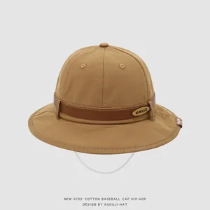 Detail of cotton kids sun hat featuring brown leather band and metallic brand logo