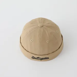 Detalle de gorra docker caqui con bordado negro de Los Ángeles y textura de sarga de algodón
