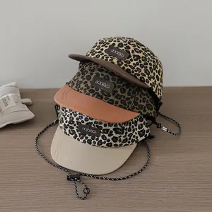 Close-up of leopard print baseball caps with leather Dream patch and adjustable cords