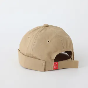 Detalle del gorro docker de algodón caqui con correa de velcro y etiqueta de logo