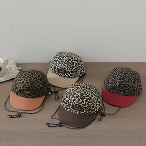 Detail view of four leopard print kids' baseball caps with adjustable windproof drawstrings