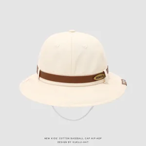 Detail of cream cotton kids sun hat with brown leather strap and gold metal brand logo