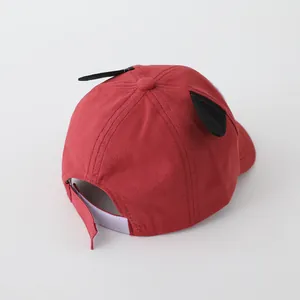 Detail of red kids baseball cap featuring cute black animal ears and velcro strap closure