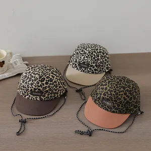 Detail of kids baseball hats featuring leopard print, contrast brims, and dream labels