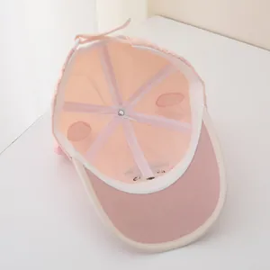 Detail view of pink baseball cap interior with reinforced seams and adjustable tie strap