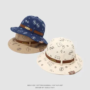 Détail de chapeaux bobs pour enfants en bleu marine, kaki et crème avec motifs d'ours