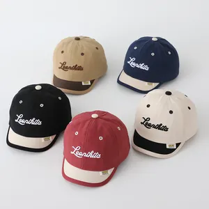 Detailed close-up of five two-tone cotton canvas baby baseball caps with Leonkita embroidery